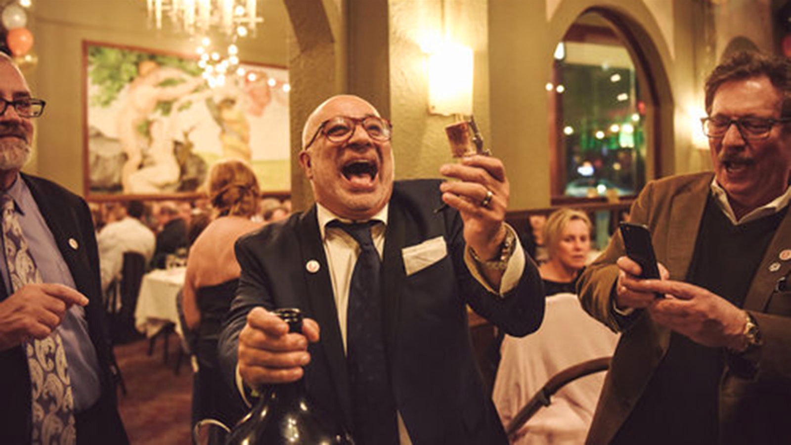 Mauro Golmarvi smiling after opening a bottle of wine at his Assaggio Ristorante in Seattle